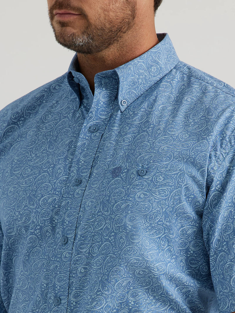 Man wearing short sleeve button front shirt in a blue paisley print