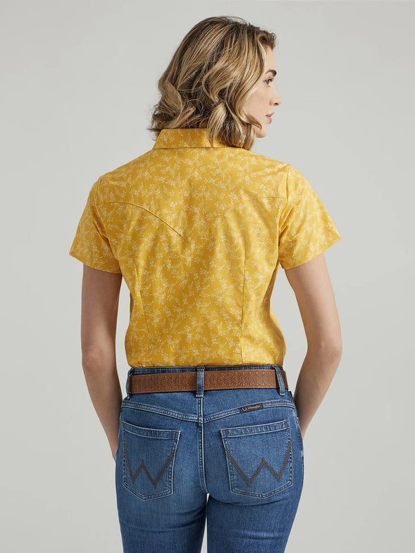 Woman wearing short sleeve yellow pearl snap shirt