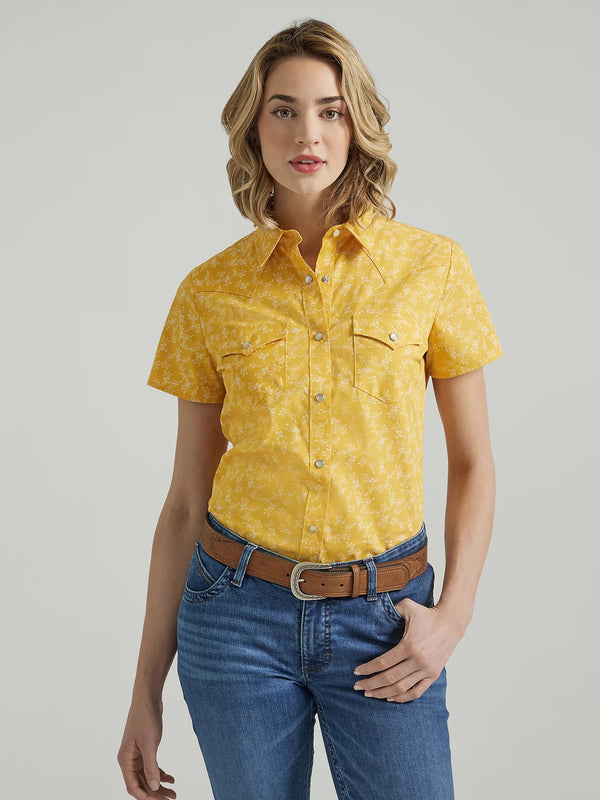 Woman wearing short sleeve yellow pearl snap shirt