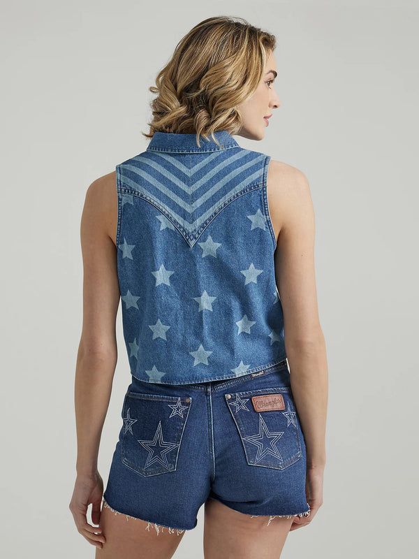 Woman wearing sleeveless denim shirt that ties in the front and has bleached stars throughout