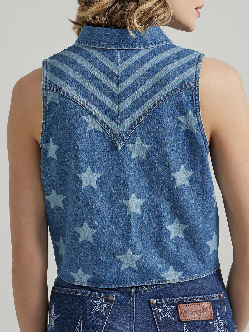 Woman wearing sleeveless denim shirt that ties in the front and has bleached stars throughout