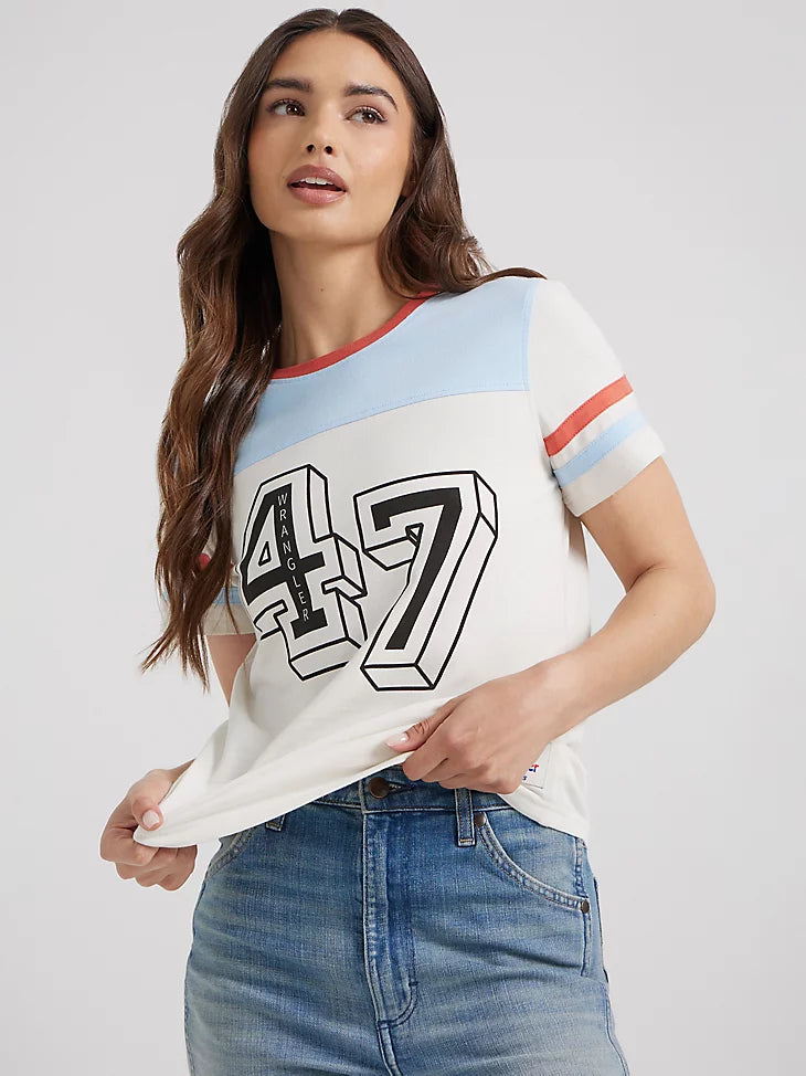 Woman wearing vintage inspired tee with red white and blue colorway with number 47 in the center with wrangler in the number 4