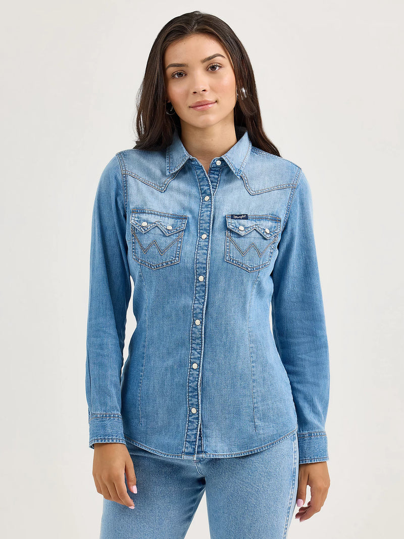Woman wearing a light blue denim shirt with a white background
