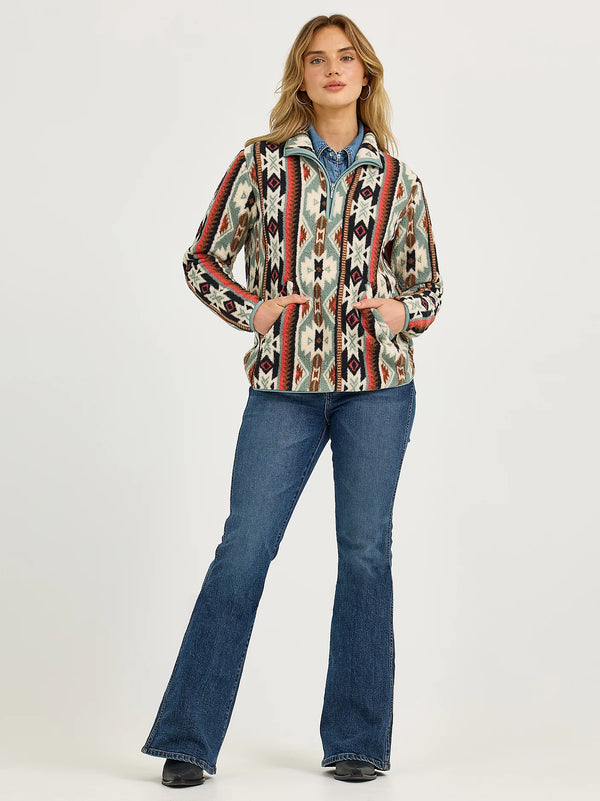 Woman wearing a patterned jacket and blue jeans on a white background