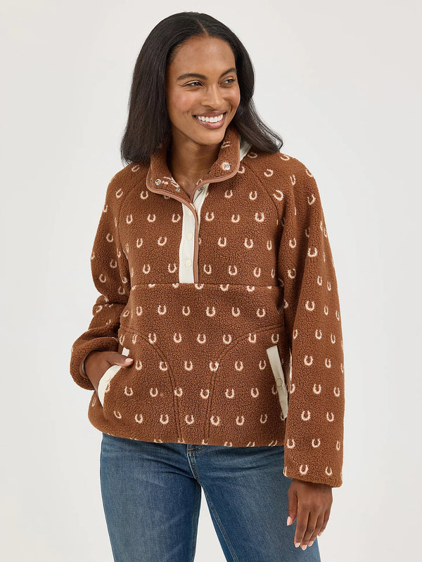 Woman wearing a brown patterned pullover with blue jeans on a white background