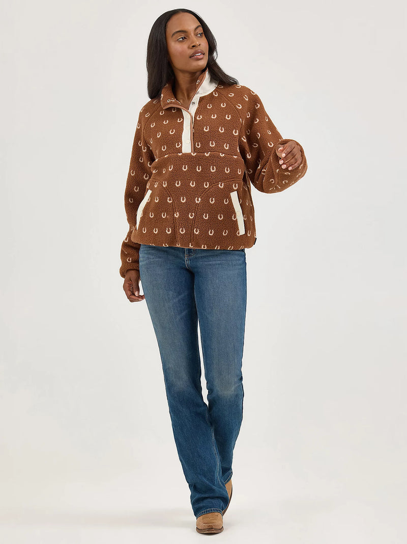 Woman wearing a brown patterned shirt and blue jeans on a white background