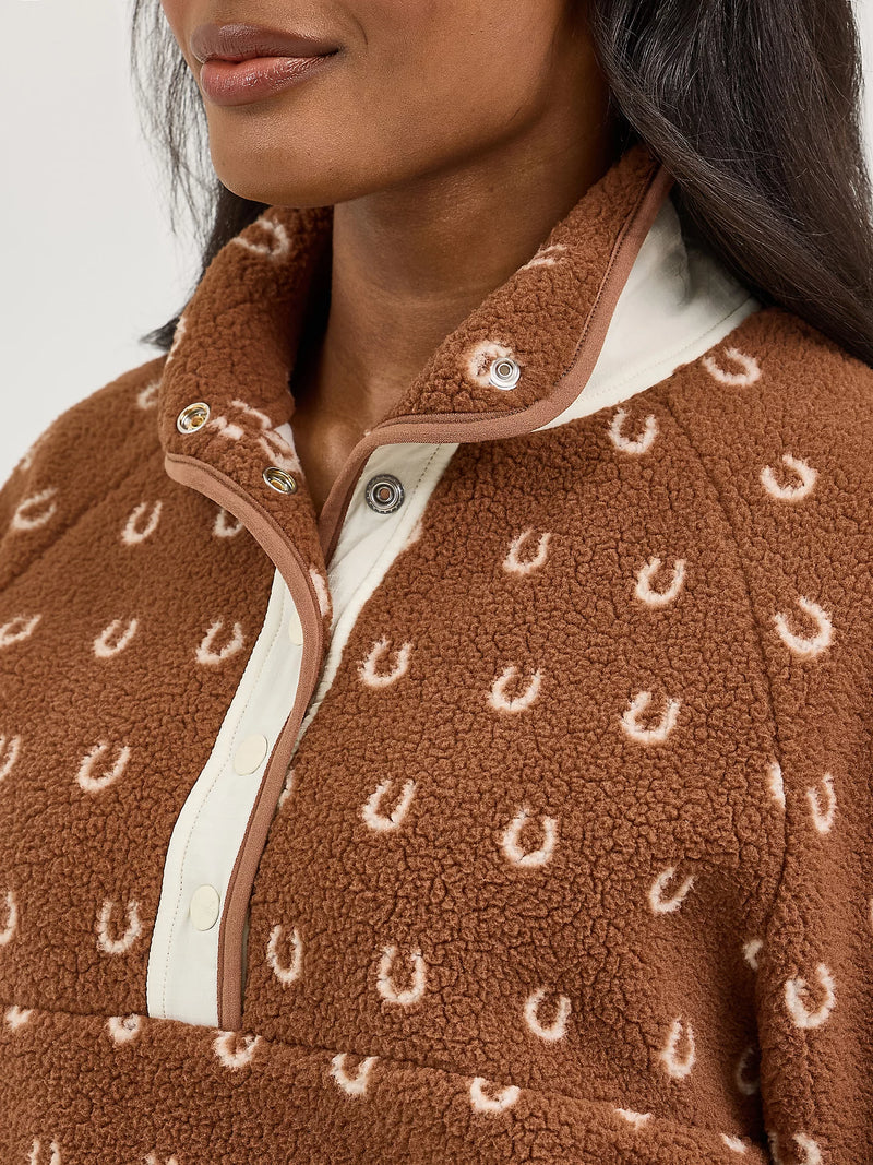 Brown fleece jacket with horse shoe pattern worn by a person