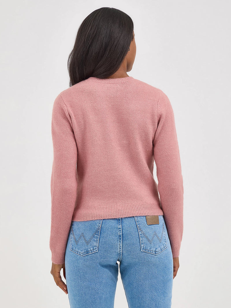 Person wearing a pink sweater and blue jeans on a white background