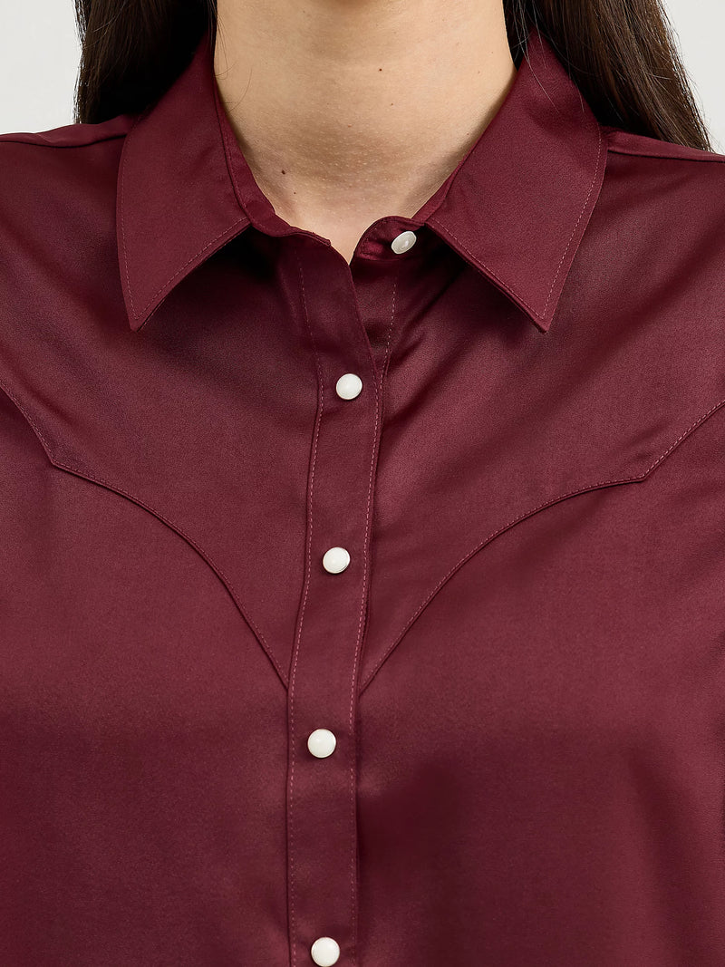 Close-up of a burgundy shirt with a collar and buttons.