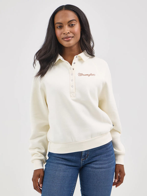 Woman wearing a cream-colored sweater with a logo on a white background