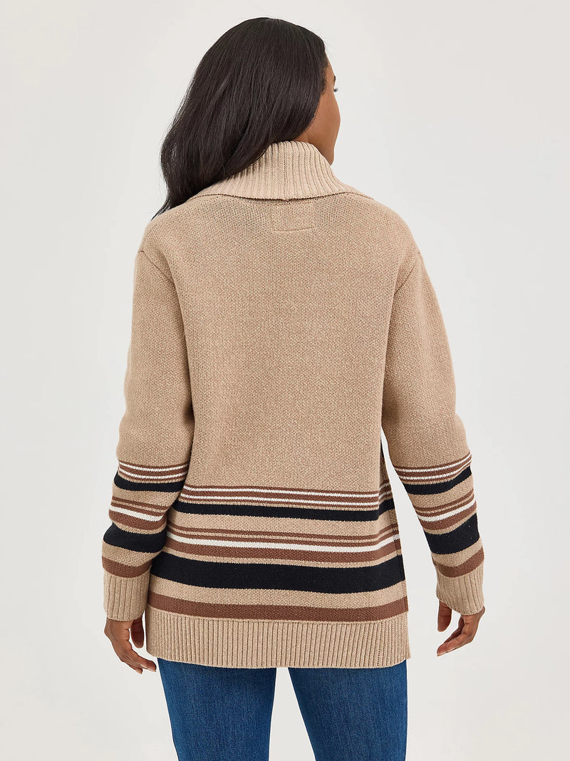 Woman wearing a beige sweater with striped sleeves on a white background