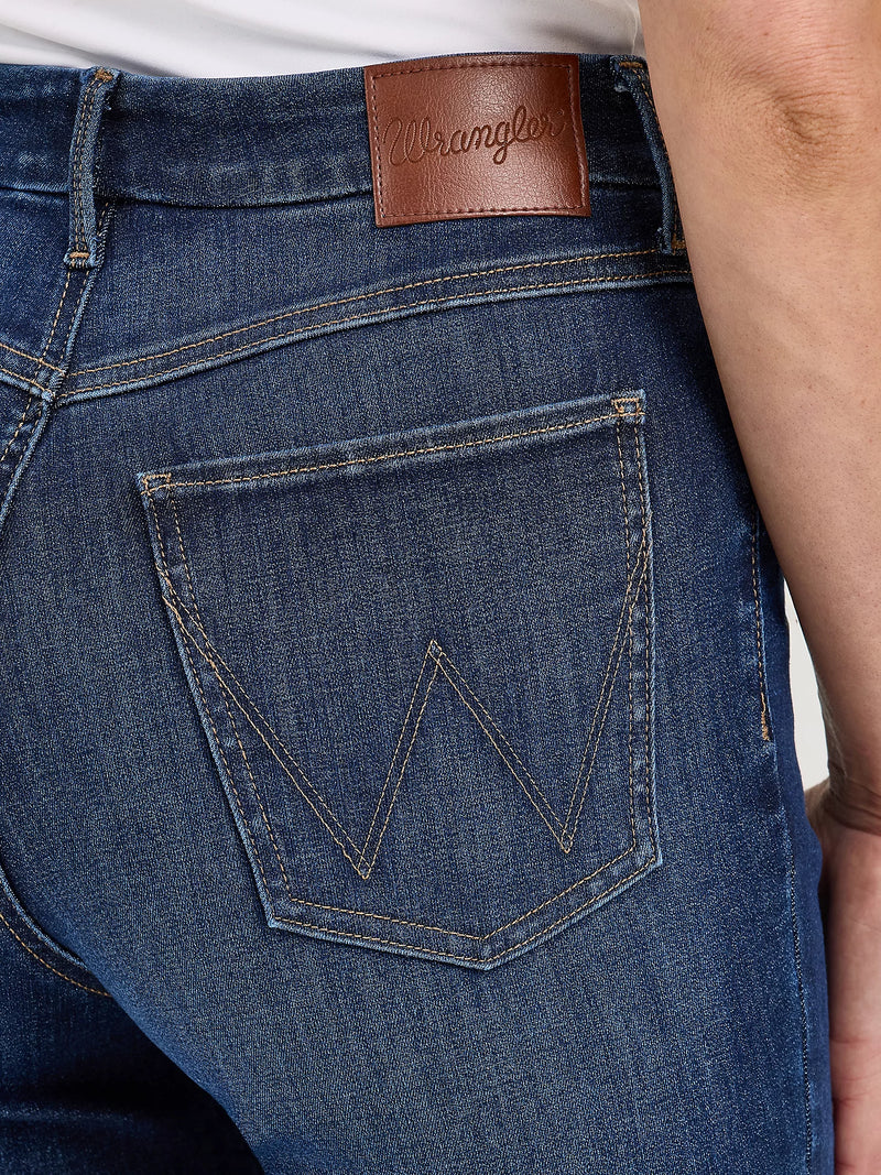 Close-up of blue jeans with a Wrangler logo on the pocket and brand name on the waistband.