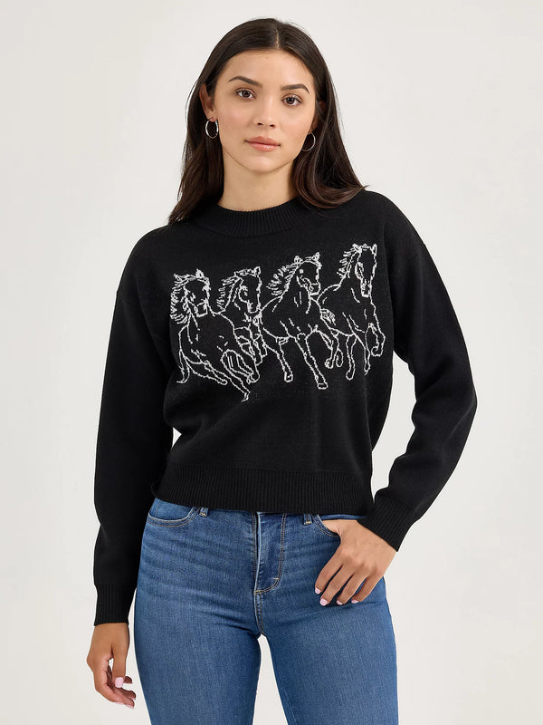 Woman wearing a black sweater with horse designs on a white background