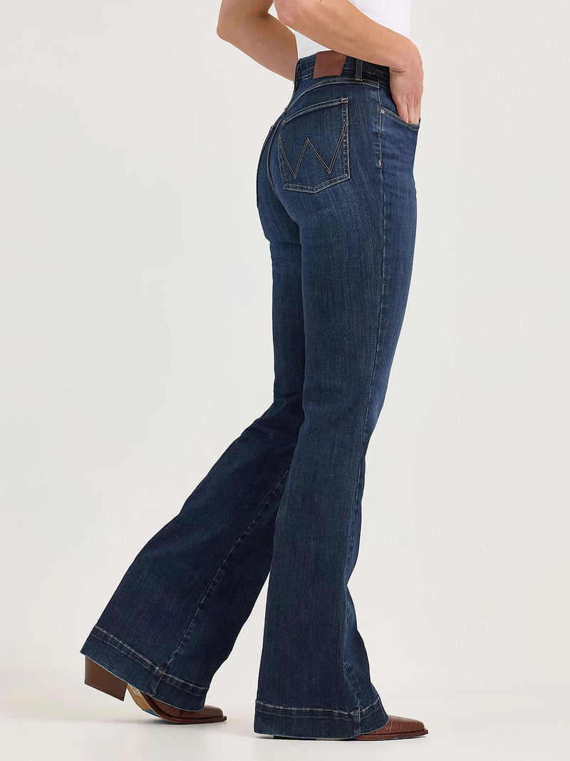 Person wearing blue flared jeans on a white background