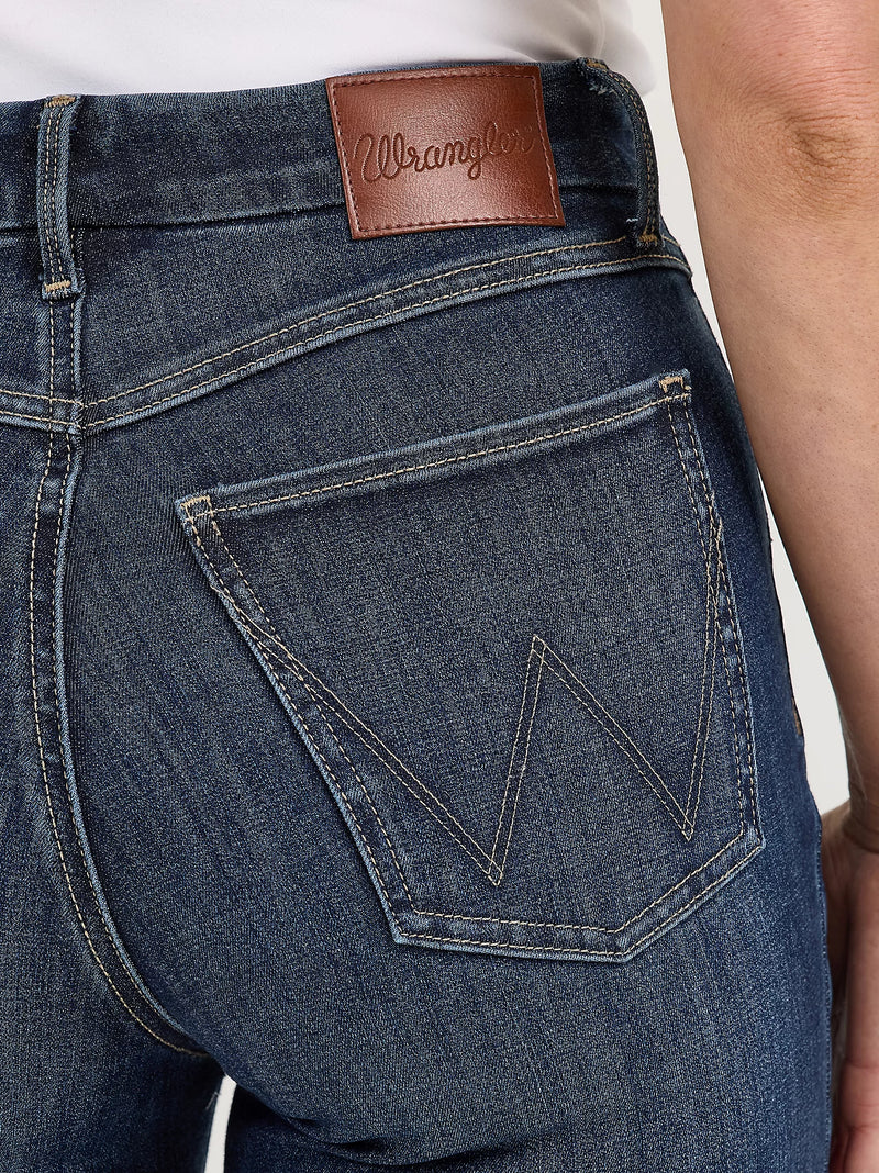 Close-up of blue jeans with a brown leather patch displaying 'Wrangler' branding.
