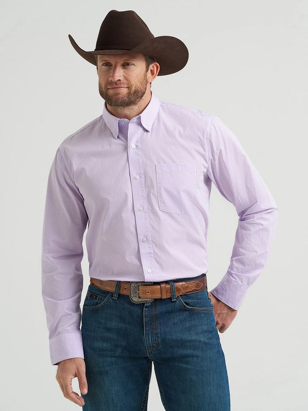 Man wearing a purple shirt, blue jeans, and a brown cowboy hat on a light gray background