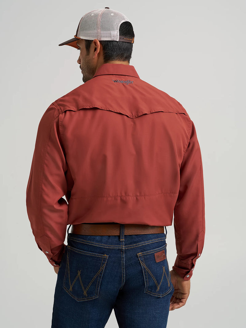 Man wearing a red jacket and blue jeans with a neutral background