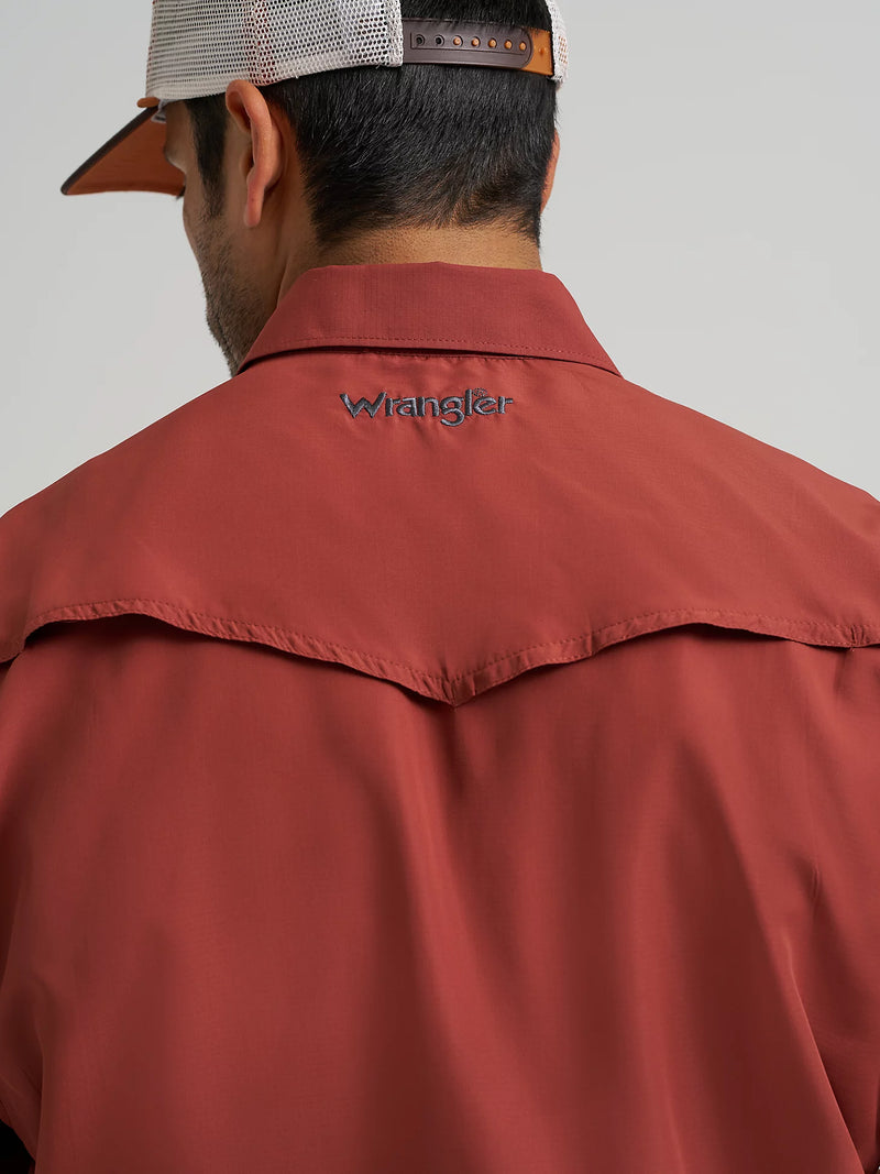 Person wearing a red jacket with 'Wrangler' branding on a plain background