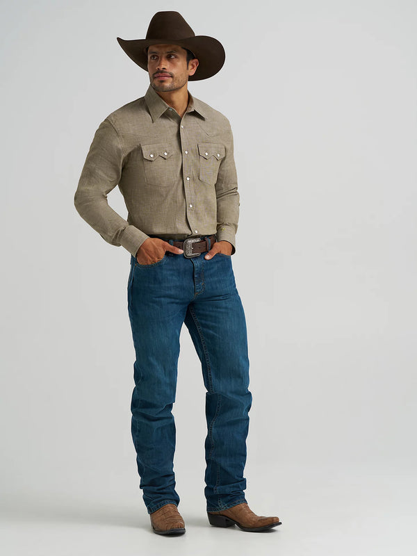 Man wearing a beige shirt, blue jeans, and a brown cowboy hat on a white background