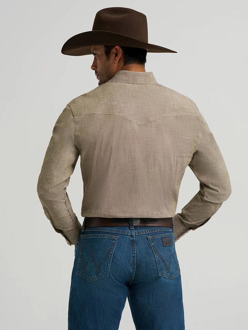 Man wearing a beige shirt, blue jeans, and a brown cowboy hat on a light gray background