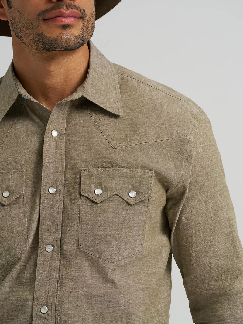 Man wearing a brown button-up shirt with a neutral background