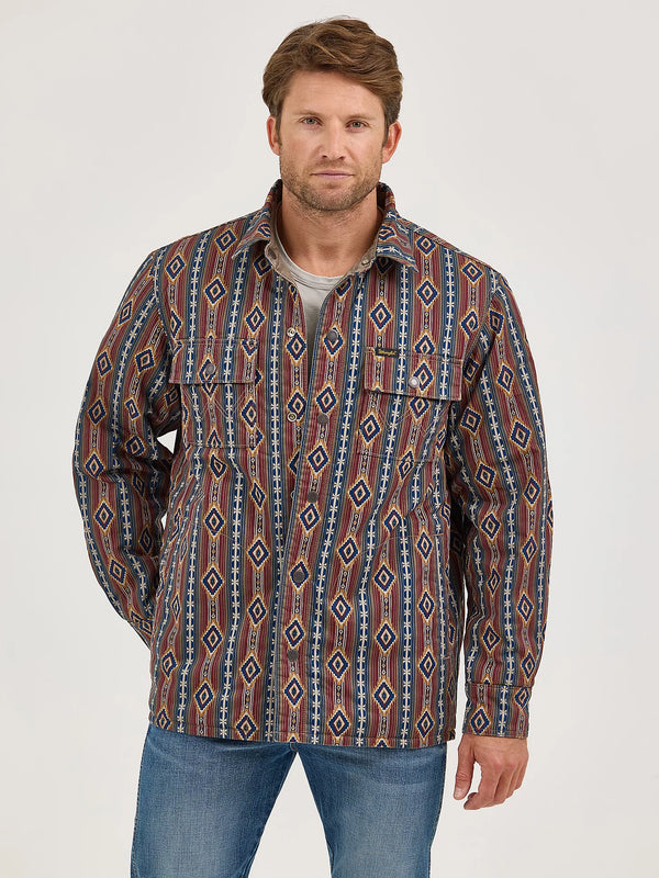 Man wearing a patterned shirt with a neutral background