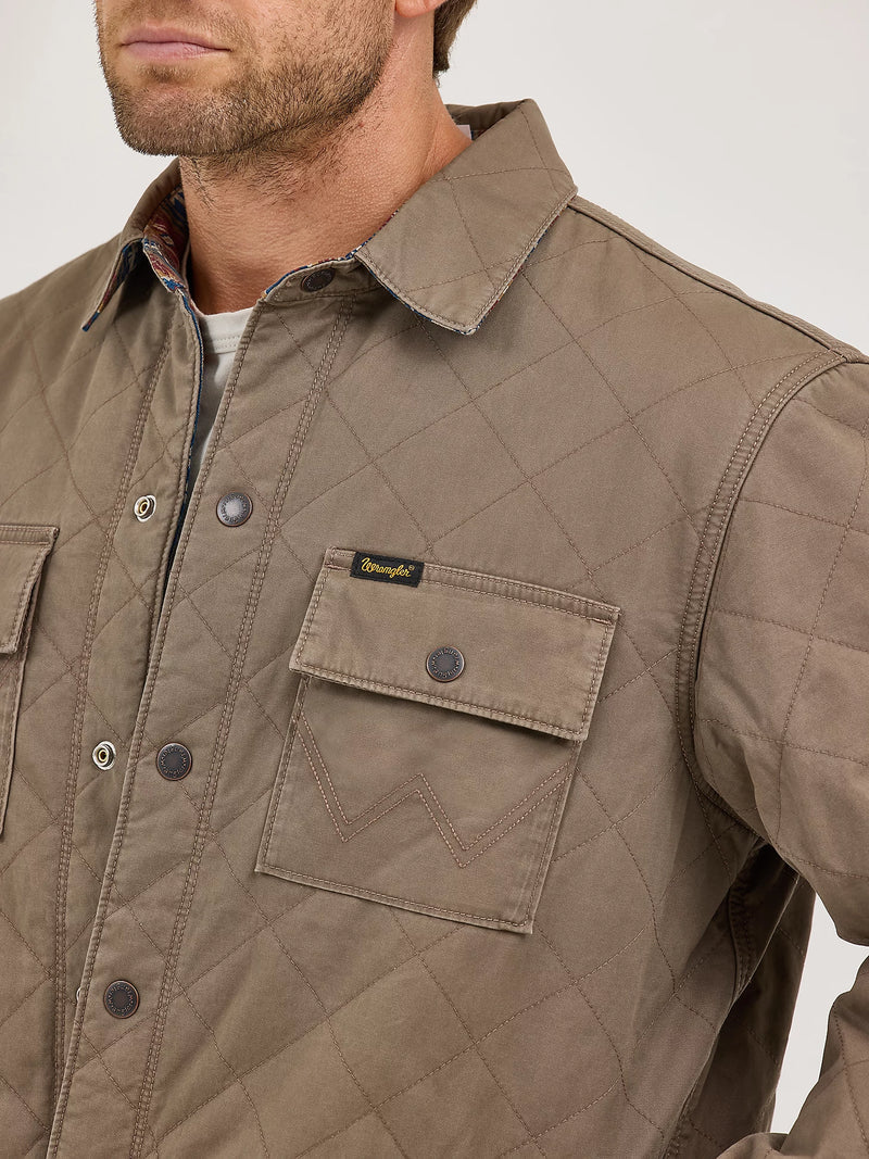 Close-up of a brown quilted jacket with a brand logo on a white background