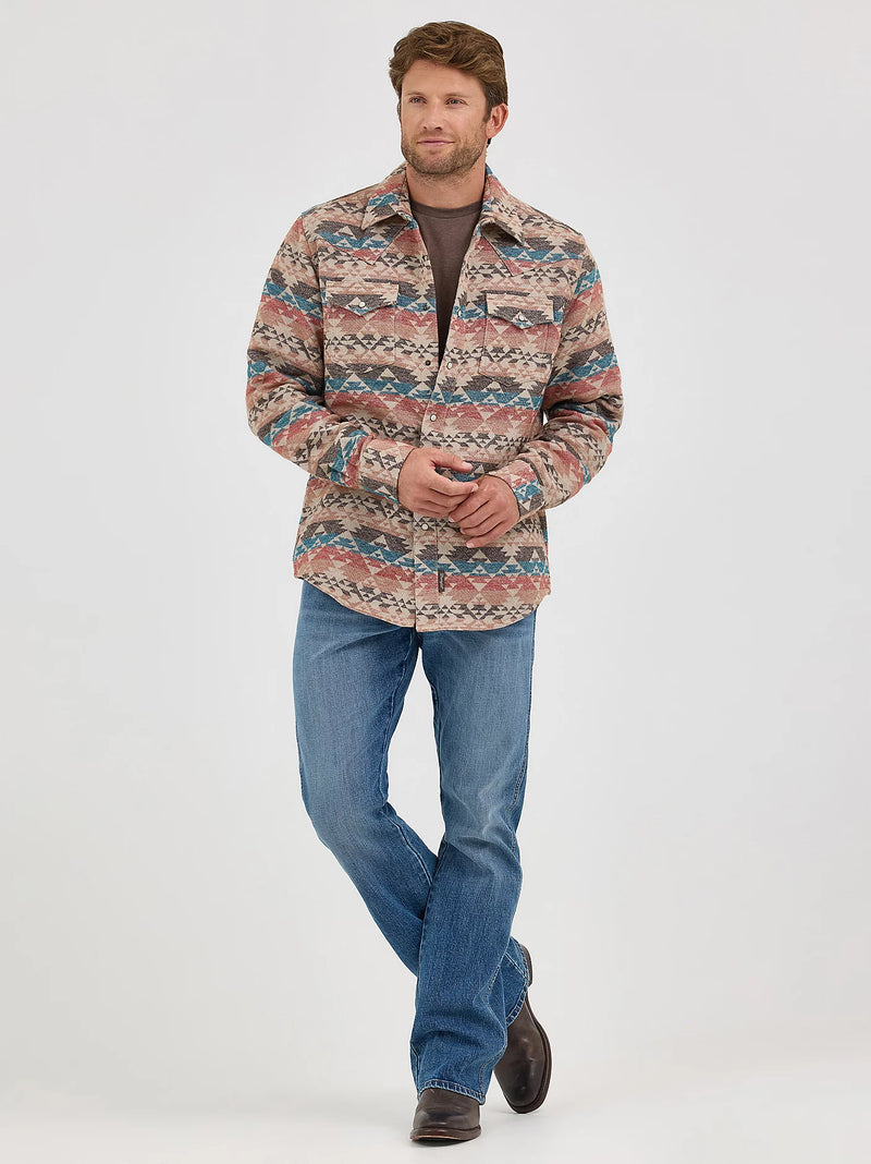 Man wearing a patterned shirt and blue jeans on a white background