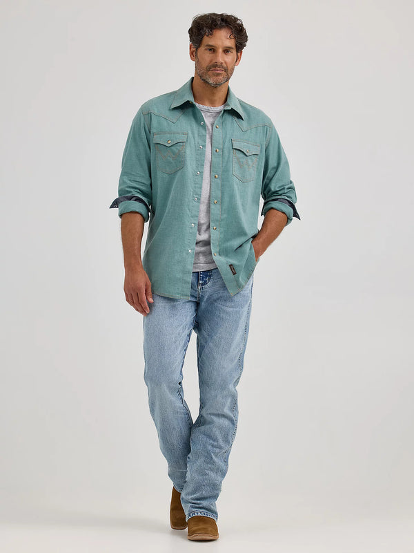 Man wearing a light green shirt, gray t-shirt, and blue jeans on a white background