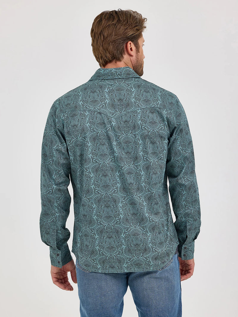 Man wearing a patterned shirt and jeans on a white background