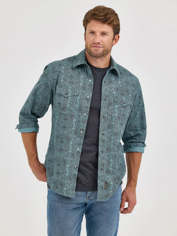 Man wearing a patterned shirt over a dark t-shirt with rolled-up sleeves on a white background
