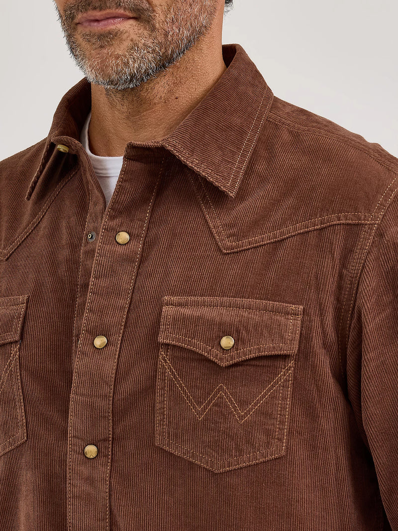 Brown corduroy shirt worn by a person on a white background