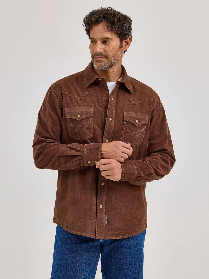 Man wearing a brown corduroy shirt and blue jeans on a white background