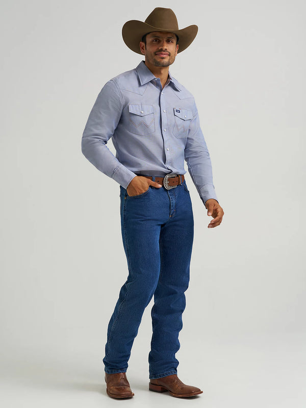 Man wearing a blue shirt, jeans, and a cowboy hat on a light gray background