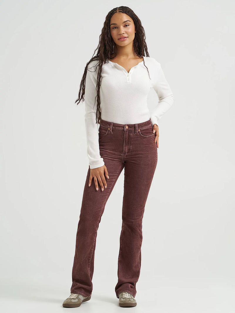 Woman wearing brown corduroy pants and a white long-sleeve shirt on a white background