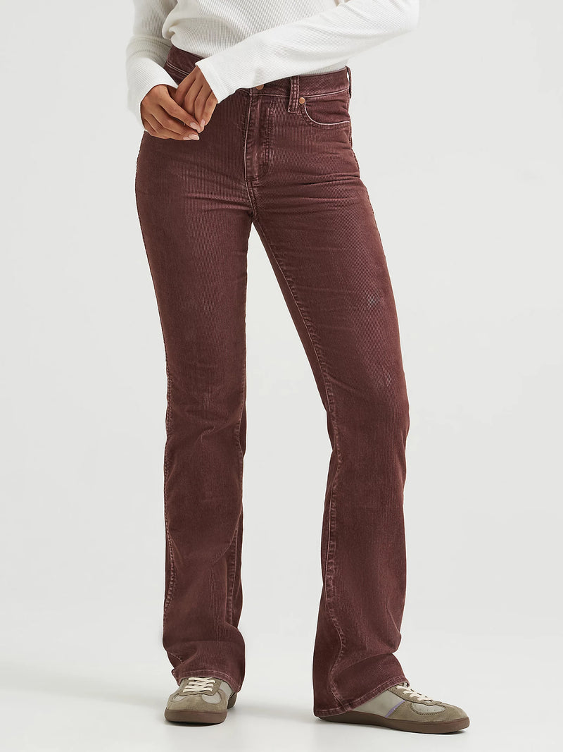 Brown corduroy pants worn by a person on a white background