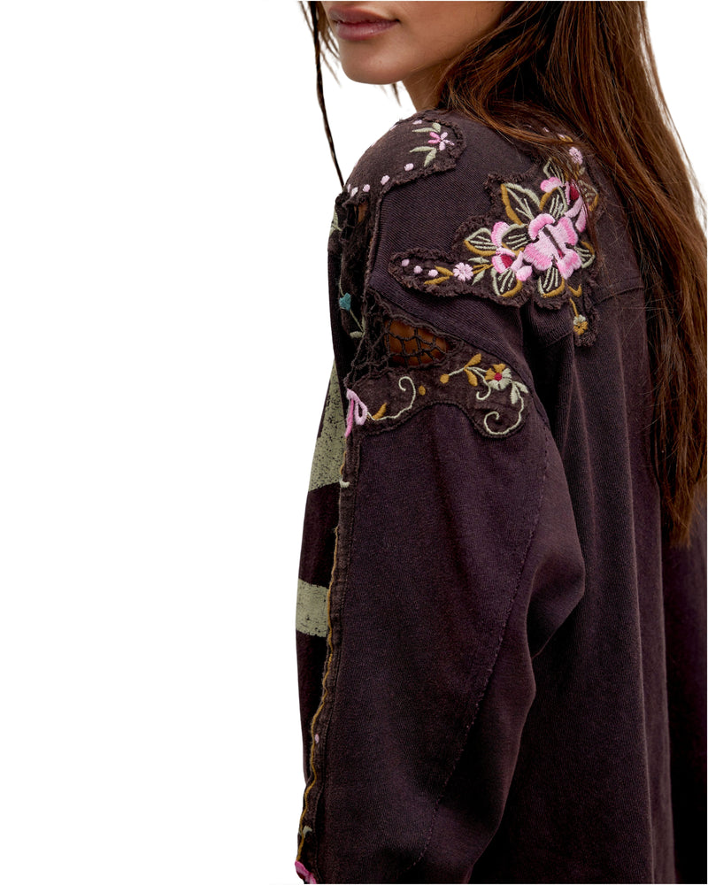 Close-up of a dark brown jacket with floral embroidery on a white background