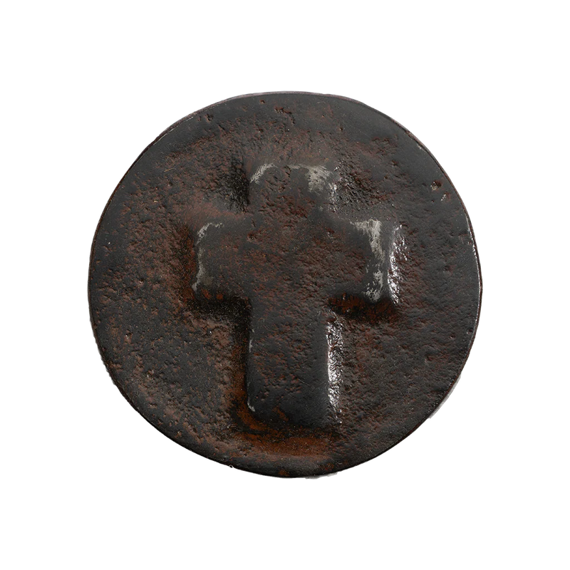 Rust-colored metal button with a cross design on a white background
