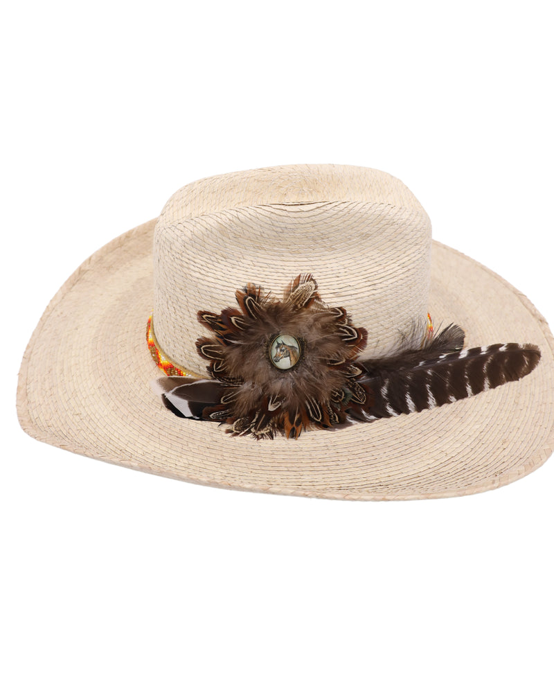 Straw cowboy hat features a vibrant hatband with intricate hand-beaded detailing in colors of orange, yellow, red, white, and brown. The side displays a beautifully crafted image of a horse framed by feathers, with large feathers tucked into the band.