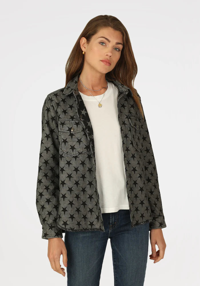 Woman wearing grey jacket with black stars all over with double breast pockets 