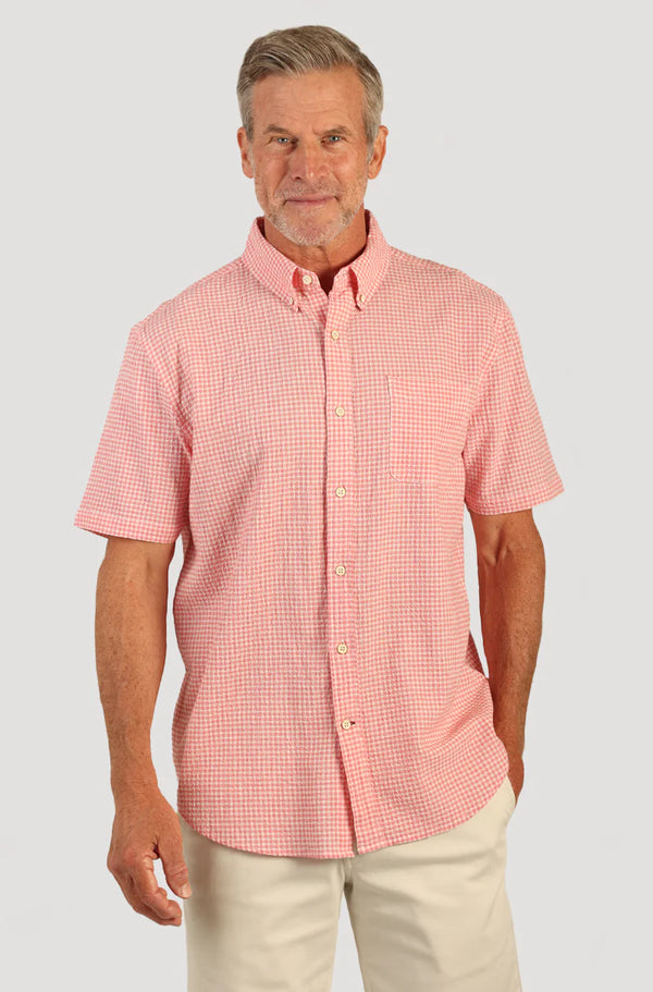 Man wearing short sleeve button front shirt with collar, pink and white checker print and single breast pocket 