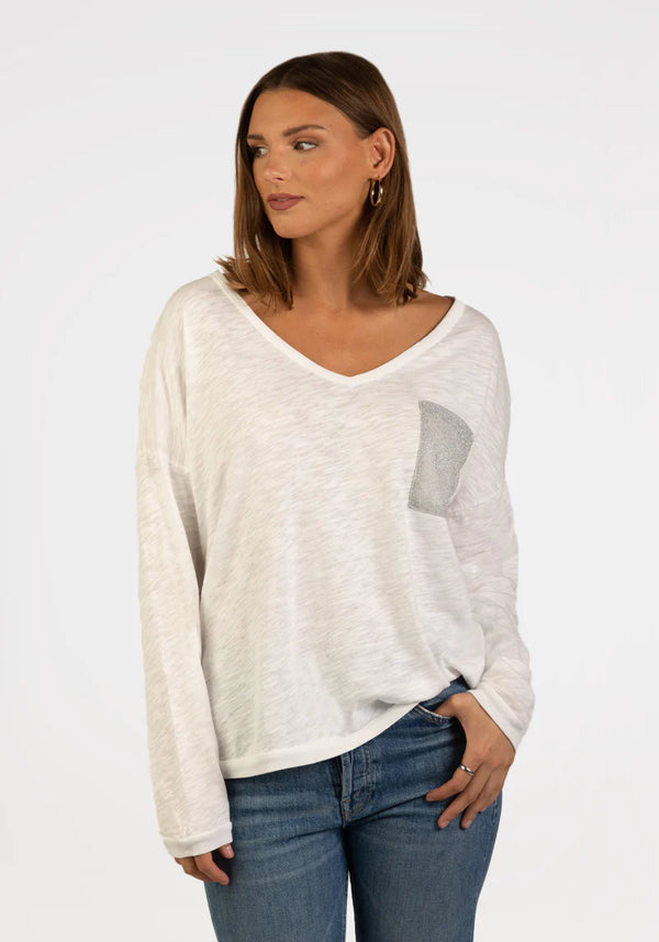 Woman wearing white long sleeve, v-neck top with pocket