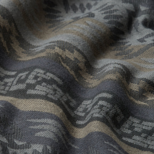 CLOSE UP OF FABRIC IN WHICH THE SHIRT IS MADE OF SHOWCASING GREY AND TAN AZTEC PATTERN