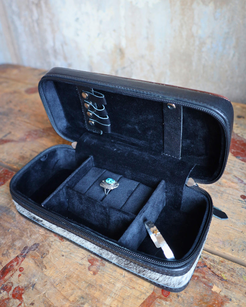 Mini plus travel jewelry case with floral tooled leather and white bucksitich lacing top, with hair on cowhide, black leather or dark chocolate brown leather with black velvet interior.