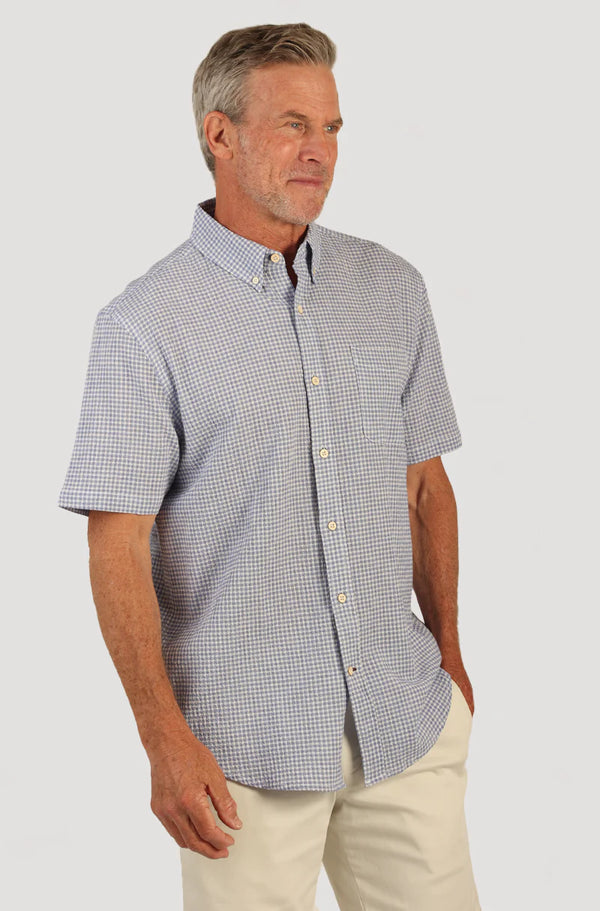 Man wearing short sleeve shirt with button front, collar, blue and white checker print and single breast pocket