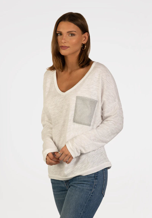 Woman wearing white long sleeve, v-neck top with pocket