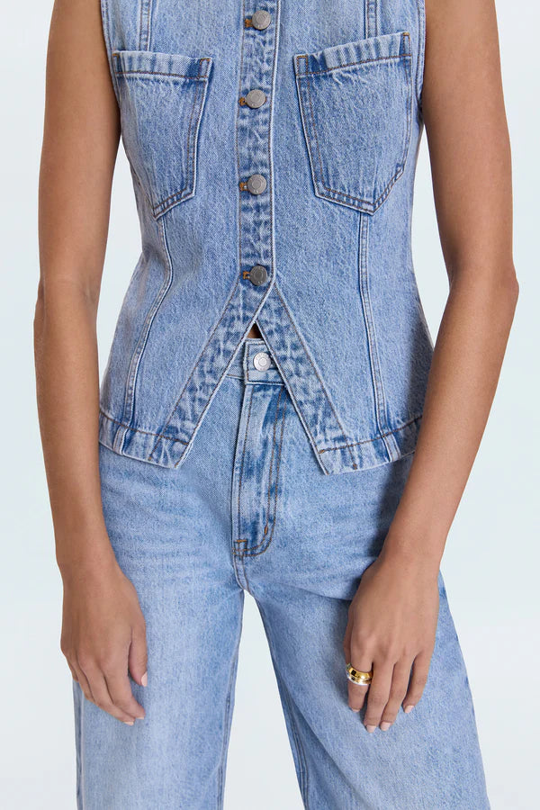 Denim vest and jeans on a plain background