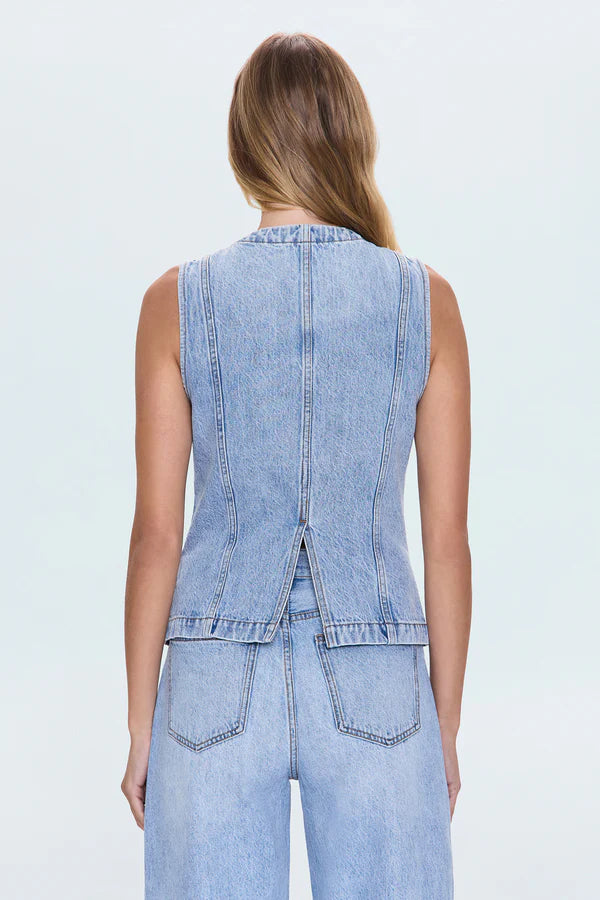 Woman wearing a light blue denim vest and pants on a white background