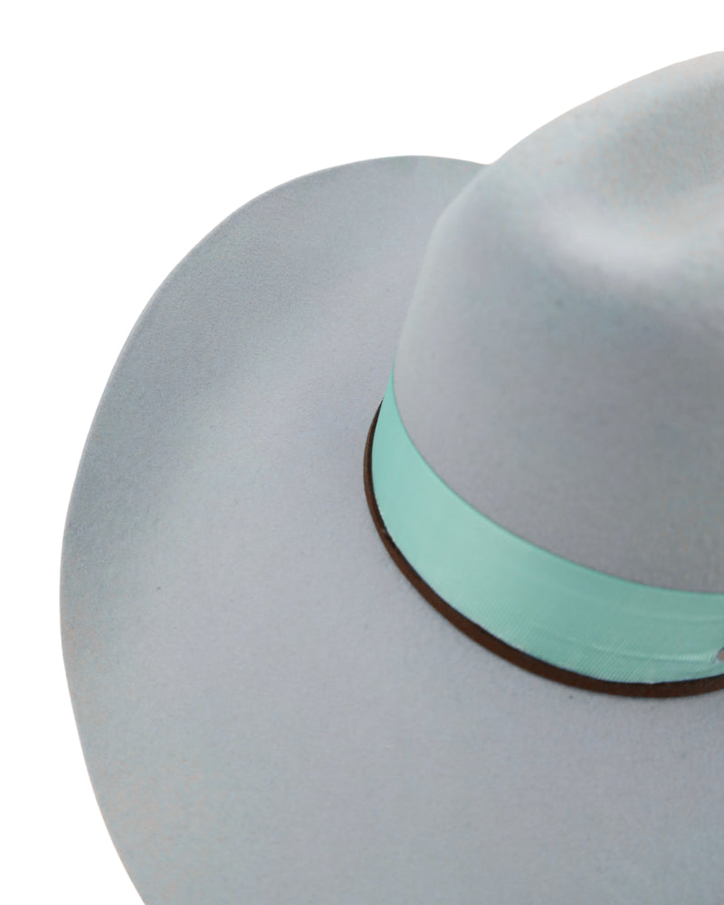 cowboy hat features a stylish blue ribbon hat band, leather strand, concho, feather, and double cross stitch detailing