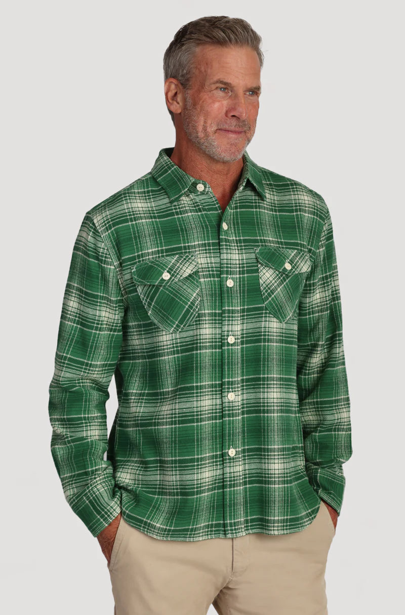 Man wearing green plaid button up shirt with double breast pockets on the front 
